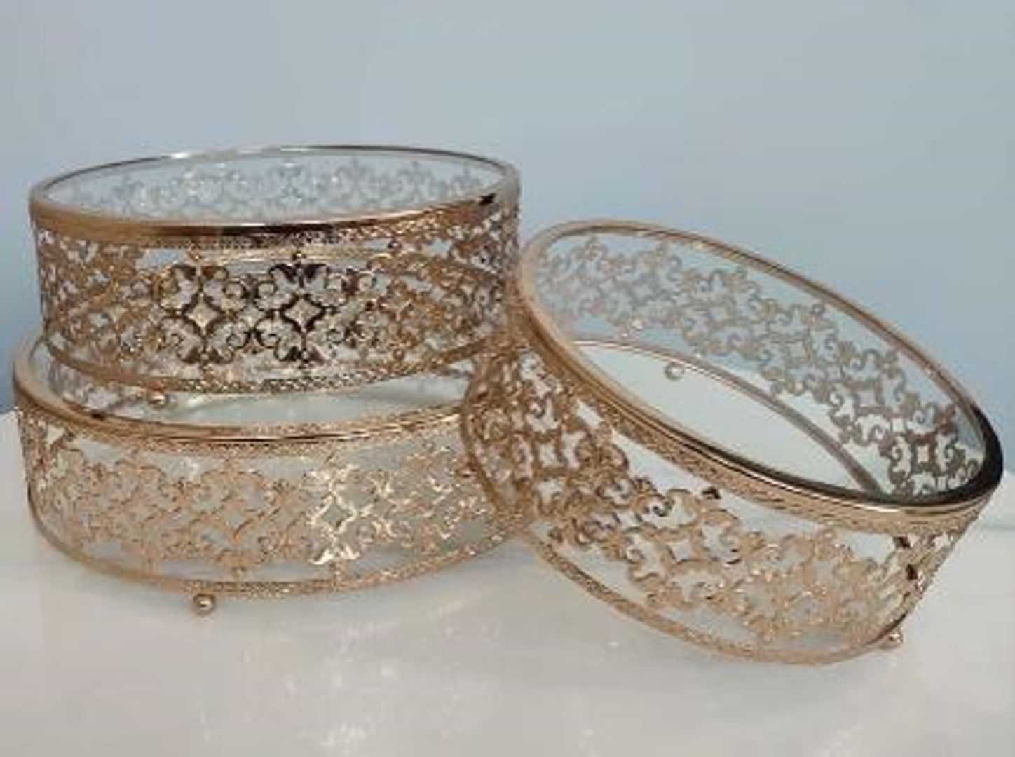 Set de tres bases en metal color dorado con acrílico