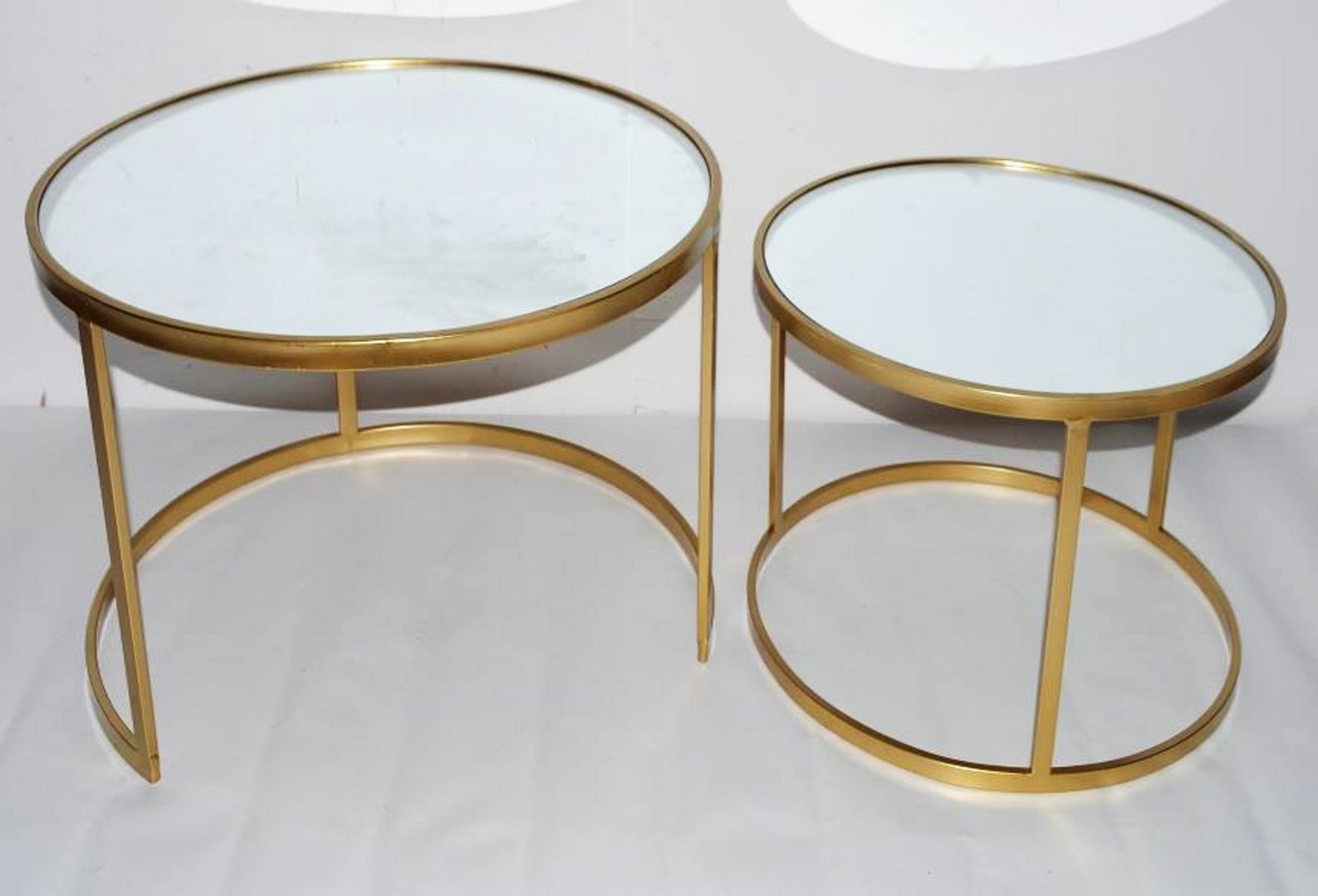 Set de dos mesas doradas con espejo.