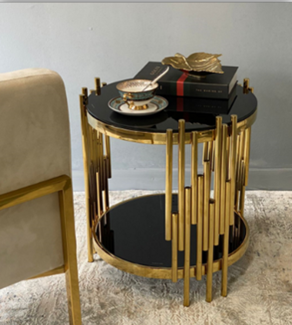 Mesa dorada en acero y vidrio negro.