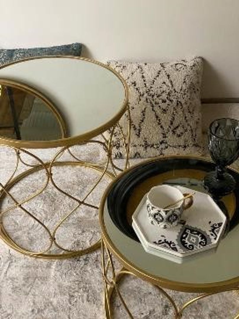 Set de dos mesas doradas con espejo.