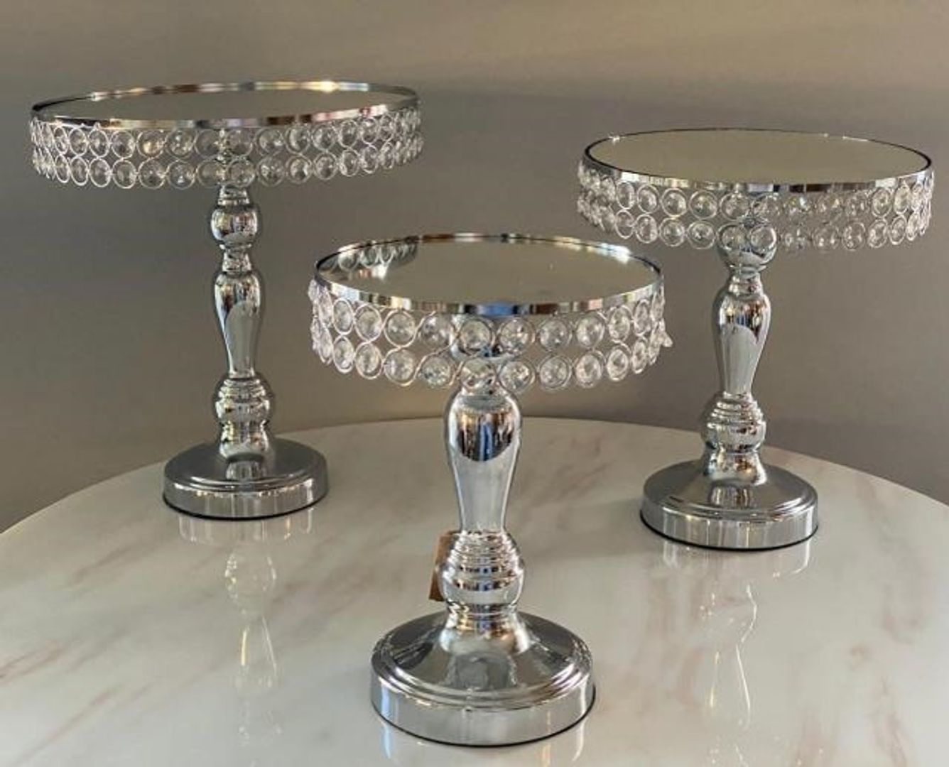 Set de tres bases en metal color plateado con espejo